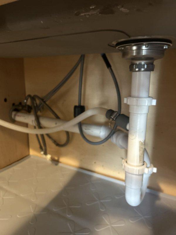 Responded to a warranty call for a slow-draining sink and a suspected leak at previously installed drain piping. Inspected the sink drain assembly, strainer flange, and PVC trap, then cleared the obstruction, tightened the slip-joint connections, and confirmed proper drainage with no leaks at the fittings.