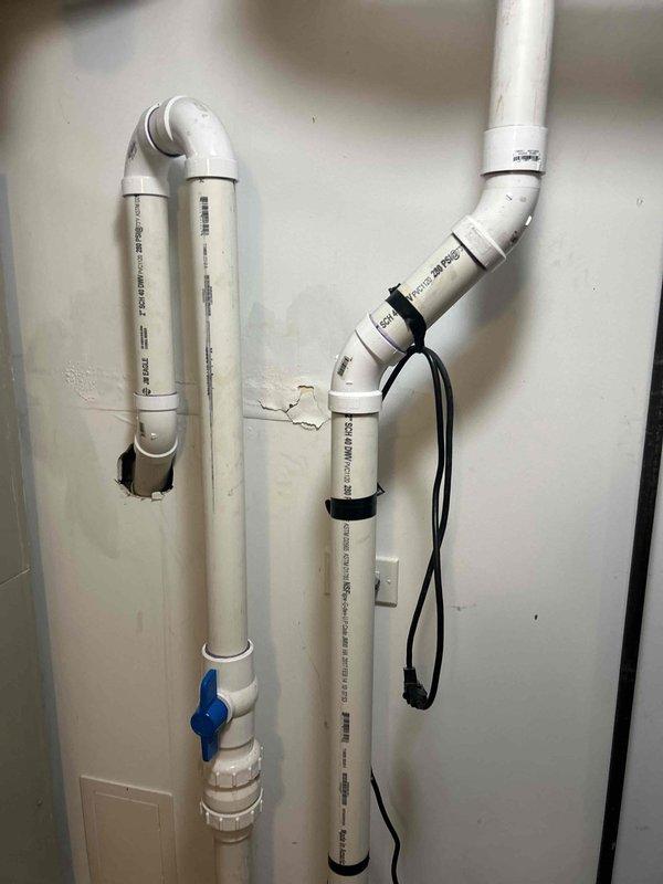 Assessed the existing sewage ejector system and prepared an estimate for removal and replacement of the pump. The installation consists of a sealed basin with a bolted cover, 2-inch Schedule 40 DWV discharge piping with a union and ball isolation valve, and a taped power cord routed to a nearby outlet. Replacement scope includes disconnecting the discharge piping at the union, removing the existing pump, installing a new ejector pump, and restoring the discharge assembly and electrical connection.