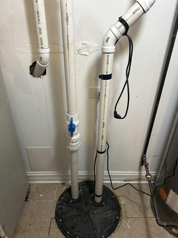 Assessed the existing sewage ejector system and prepared an estimate for removal and replacement of the pump. The installation consists of a sealed basin with a bolted cover, 2-inch Schedule 40 DWV discharge piping with a union and ball isolation valve, and a taped power cord routed to a nearby outlet. Replacement scope includes disconnecting the discharge piping at the union, removing the existing pump, installing a new ejector pump, and restoring the discharge assembly and electrical connection.