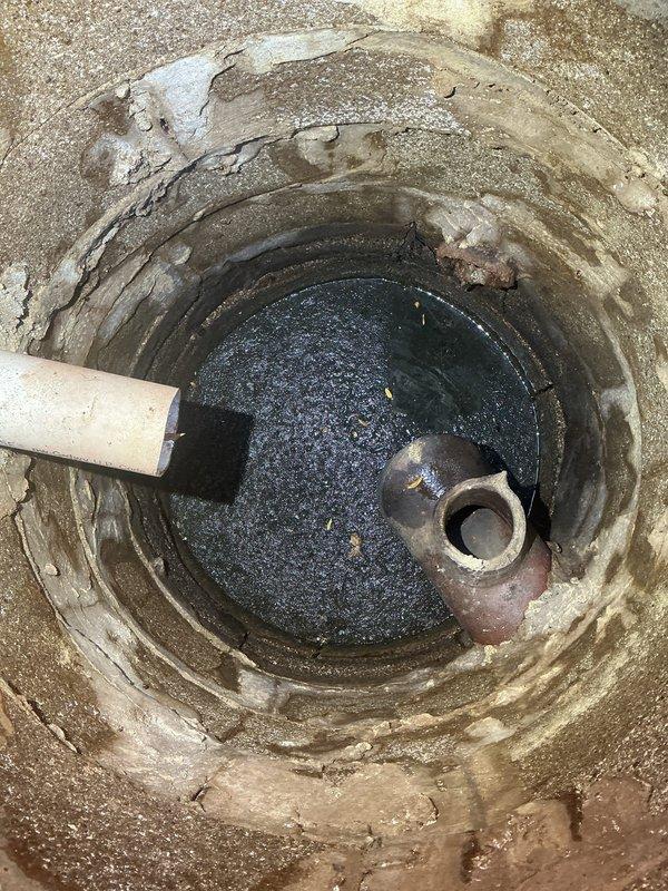 Accessed the main sewer line through the exterior cleanout and inspected the below-grade access basin, noting deteriorated masonry walls and standing water at the base. Performed a main line cleanout to clear the blockage and restore proper flow through the sewer lateral.