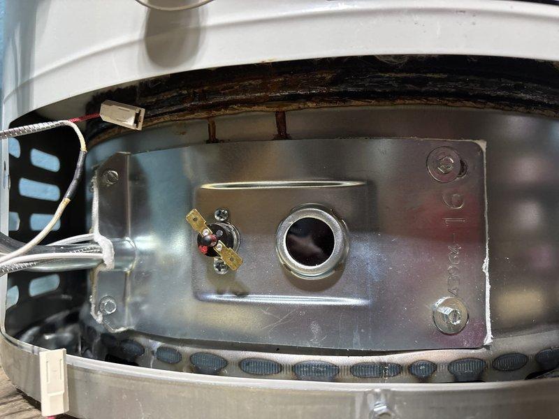 Inspected the Bradford White gas water heater and found sooting and rust staining at the burner chamber, along with a failed thermal switch (flammable vapor/flame rollout protection) mounted on the burner chamber mounting plate. Opened the outer jacket, inspected the burner assembly, wiring leads, and combustion chamber insulation, and verified draft hood and flue venting connection to the exhaust duct. Completed the sold home comfort warranty repair to restore safe, code-compliant operation of the water heater.