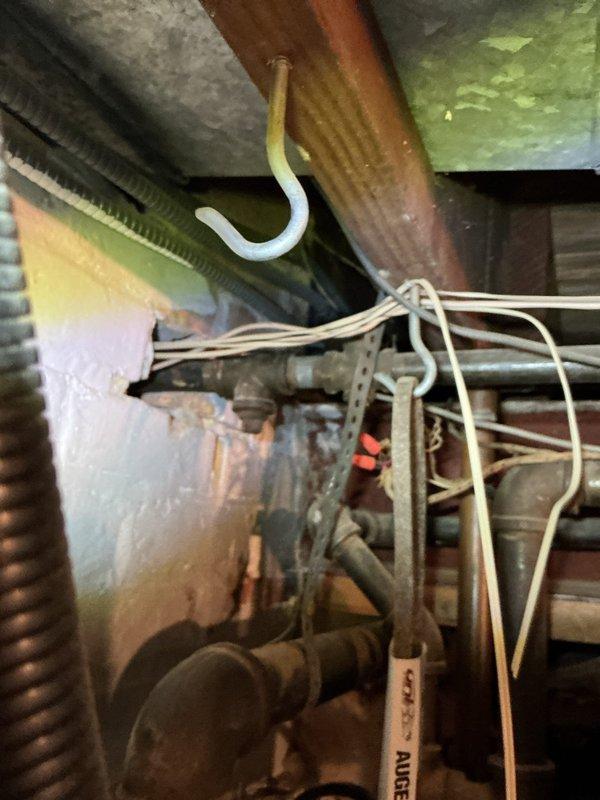 Replaced the gas line shutoff valve in the basement and performed a gas pressure test on the system to verify leak-free operation. Inspected the surrounding aged iron and galvanized gas piping and threaded fittings, noting loose low-voltage wiring draped across the piping. Also inspected the gas fireplace insert serviced by the line.