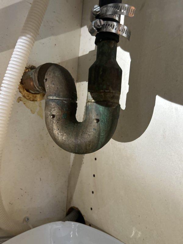 Inspected the hot water supply and under-sink plumbing to diagnose low hot water pressure, documenting the condition of the existing shutoff valves, braided supply lines, and drain assemblies, which showed corrosion, tarnishing, and moisture staining. Evaluated the valves throughout the unit for replacement and prepared a quote for adding a main shutoff valve, with a certificate of insurance to be provided for HOA approval prior to the work.