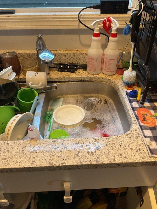 Responded to a clogged kitchen sink with standing water in the basin. Inspected the P-trap and drain assembly beneath the sink, cleared the obstruction from the drain line, and restored proper drainage. Verified unobstructed flow through the basin and drain connections, with no leaks observed at the slip-nut fittings.