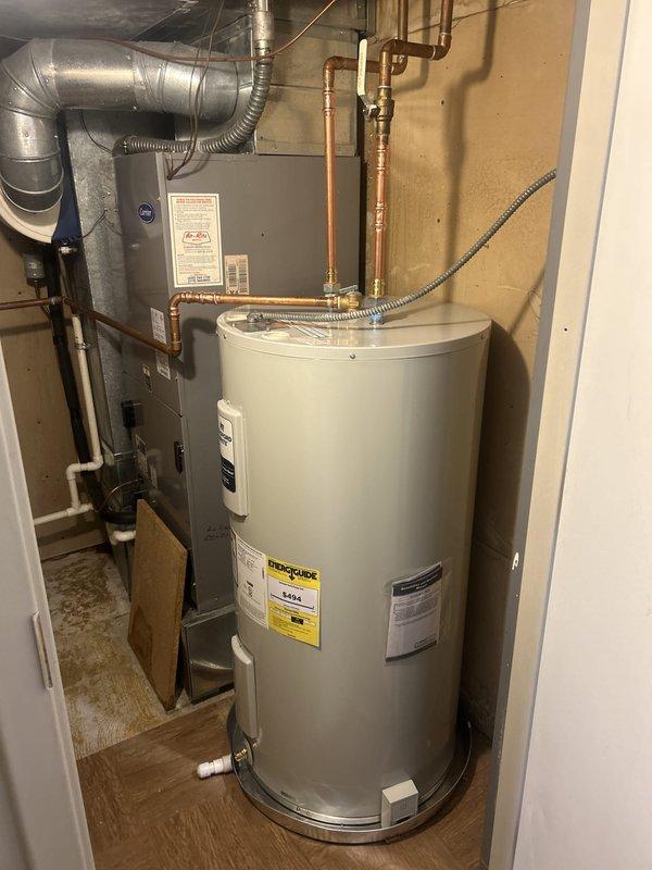 Drained and removed the existing electric water heater, hauling it off site, using the condensate drain for drainage. Installed a new 50-gallon Bradford White electric water heater in the existing location with new drain pan, capped pan drain, and water alarm. Completed electrical connections, connected to existing 3/4" water piping, and repurposed the T&P relief piping to terminate at the condensate drain.
