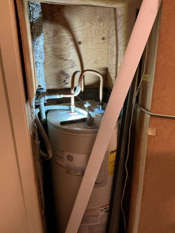 Inspected the kitchen sink supply stops and drain assembly, which showed no leaks, corrosion, or damage, and evaluated the existing GE electric tank-style water heater in the utility closet for removal and tankless replacement. Assessed the bathroom sink supply piping and the feasibility of running a copper supply line to the refrigerator for a water filter, which will require water shut-off during the work.