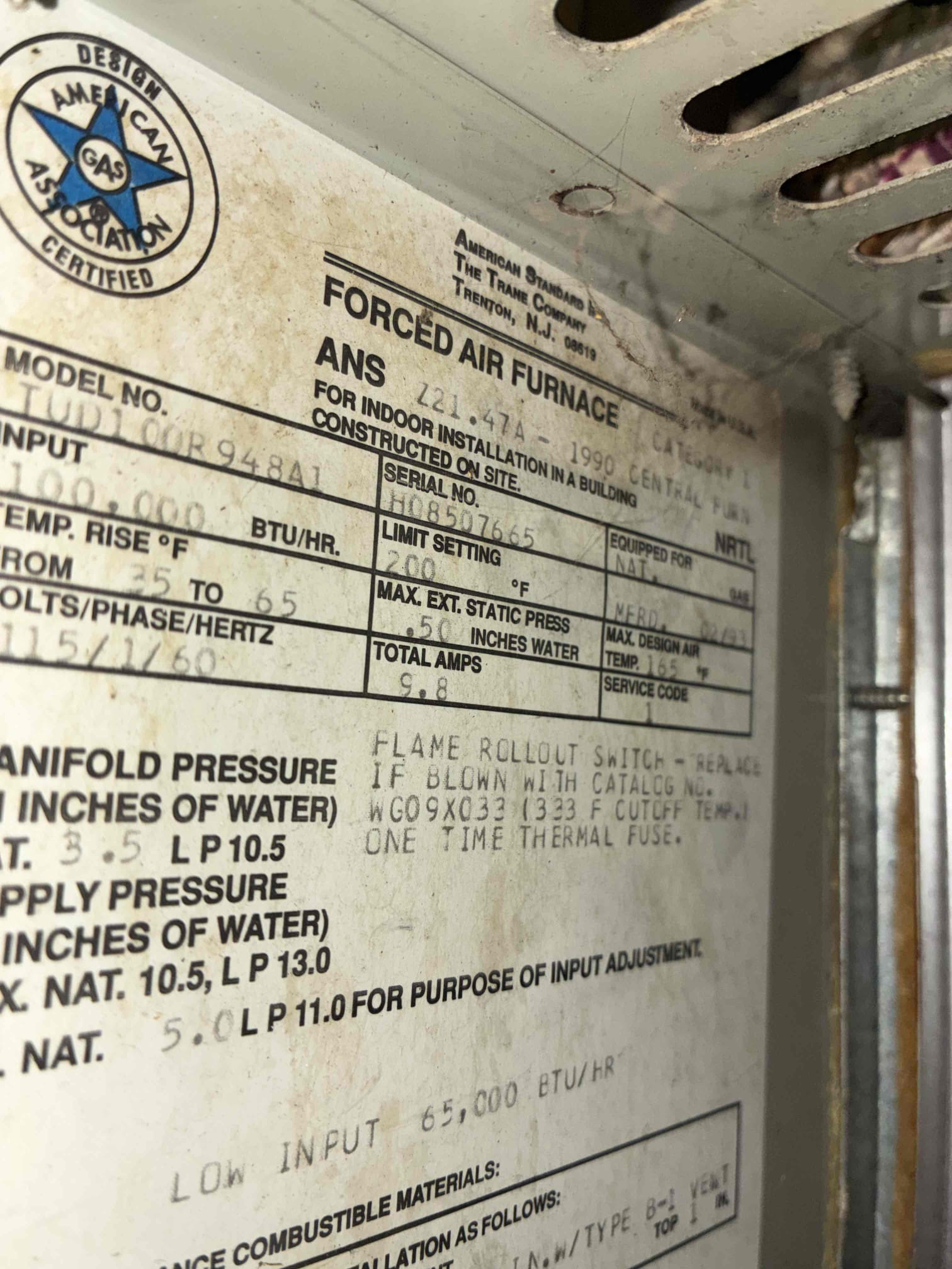 Upon inspection, the 1990 Trane gas furnace exhibited severe issues due to water intrusion from a burst water heater. The electrical components and control board showed clear signs of water damage. The blower fan operated continuously, while the inducer motor failed to energize during a heat call. Motor bearings sounded rough and noisy, indicating further damage. Given the furnace's age and the extent of water damage, full system replacement is recommended for reliability. If a short-term repair is preferred, the inducer motor, blower motor, and control board would need replacement. However, this repair is not guaranteed due to the system's age and potential unseen internal corrosion.