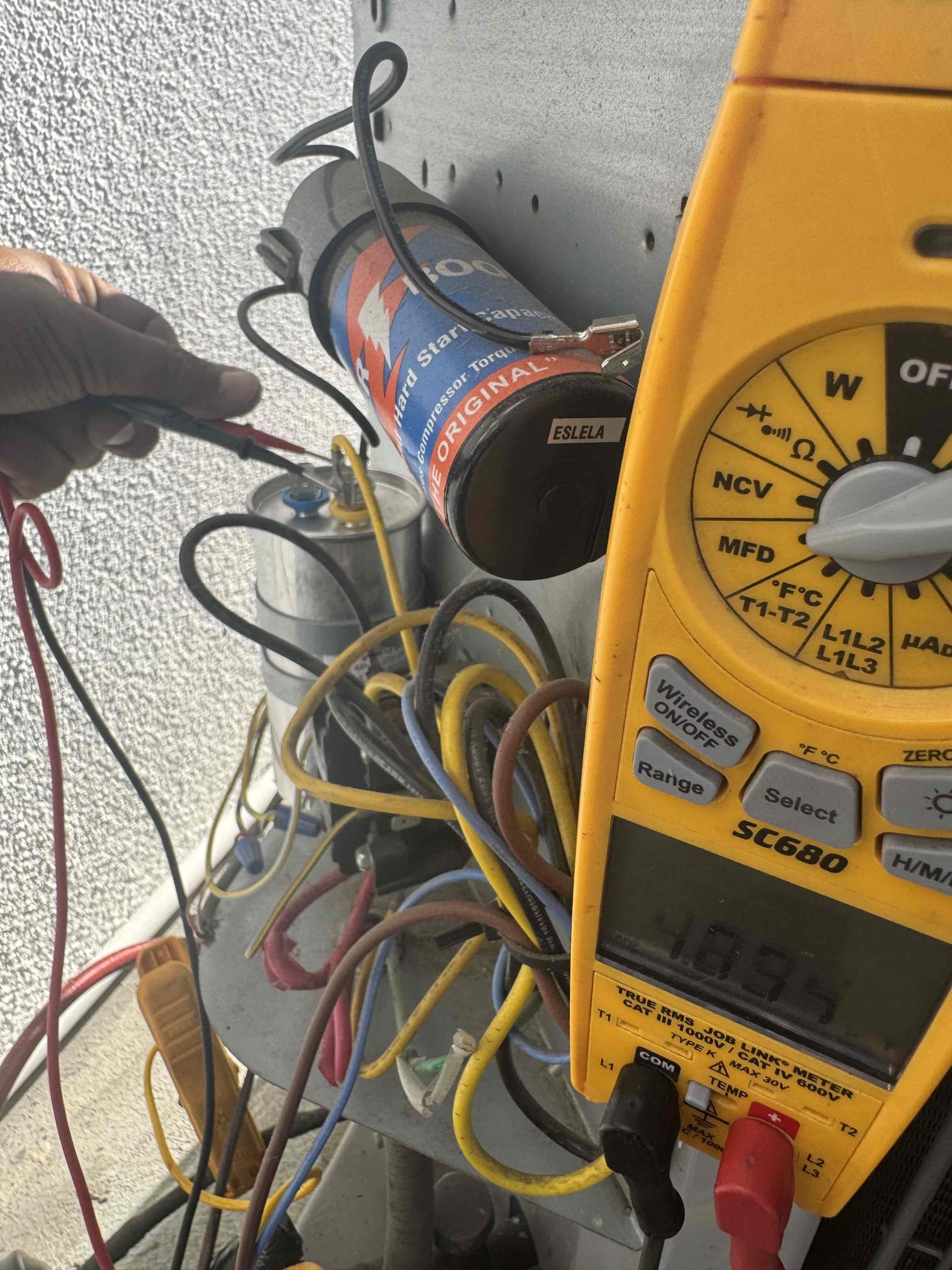 Upon receiving the customer's concern about insufficient cooling, I conducted a thorough diagnostic on the outdoor condensing unit. I verified the condenser fan motor and compressor operation, measured refrigerant pressures, temperature split, electrical components, and running amperage. The compressor and condenser fan were found to be operating normally, and the run capacitor tested within manufacturer specifications. The existing hard start kit was also functioning properly. However, the system was significantly low on refrigerant, resulting in minimal cooling capacity and a low temperature split. This indicates a likely micro refrigerant leak. I added up to 6 lbs of R-410A refrigerant to restore cooling performance, but no guarantee can be provided on how long the refrigerant charge will last due to the suspected leak.