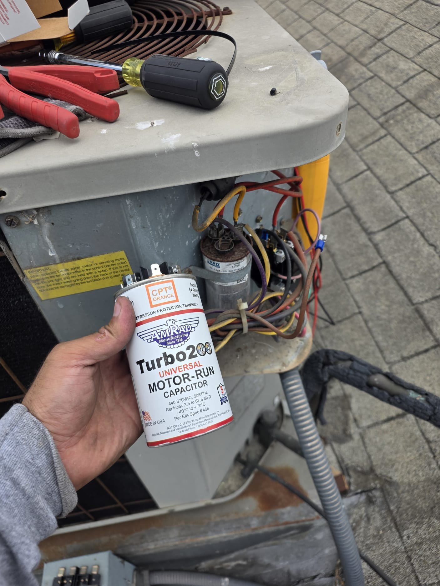 Upon inspection, it was found that the capacitor and contactor were not functioning correctly. The capacitor, rated at 50/5, showed no readings on both settings. The contactor was emitting a buzzing sound, indicating that the internal coil was not operating properly. Given the system's age, dating back to 2001, any repairs would be temporary solutions. It is highly recommended to replace the entire system for optimal performance. The repair cost is structured as a 50% deposit upfront and the remaining 50% upon completion of the work.