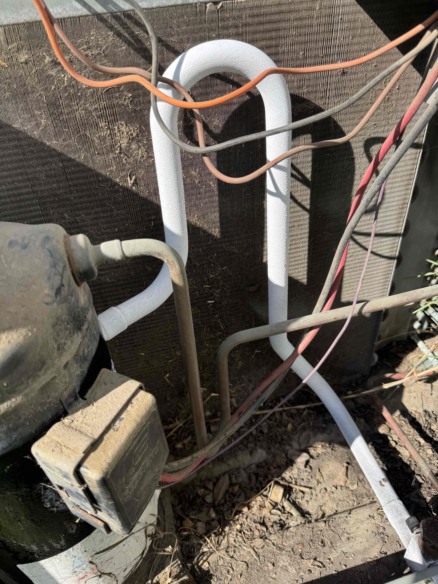 During the inspection, I identified several critical issues with the 5-ton Rheem system. The suction line was freezing, indicating a potential refrigerant leak. The blower wheel was heavily coated with dust and dirt, significantly restricting airflow. The outdoor contactor showed signs of pitting, and the capacitor needed replacement. I performed a thorough blower-wheel cleaning, replaced the contactor and capacitor, applied a leak sealant, and added up to 4 lbs of R-22 refrigerant. However, due to the system's age and use of obsolete refrigerant, these repairs are temporary. A full system replacement is strongly recommended.