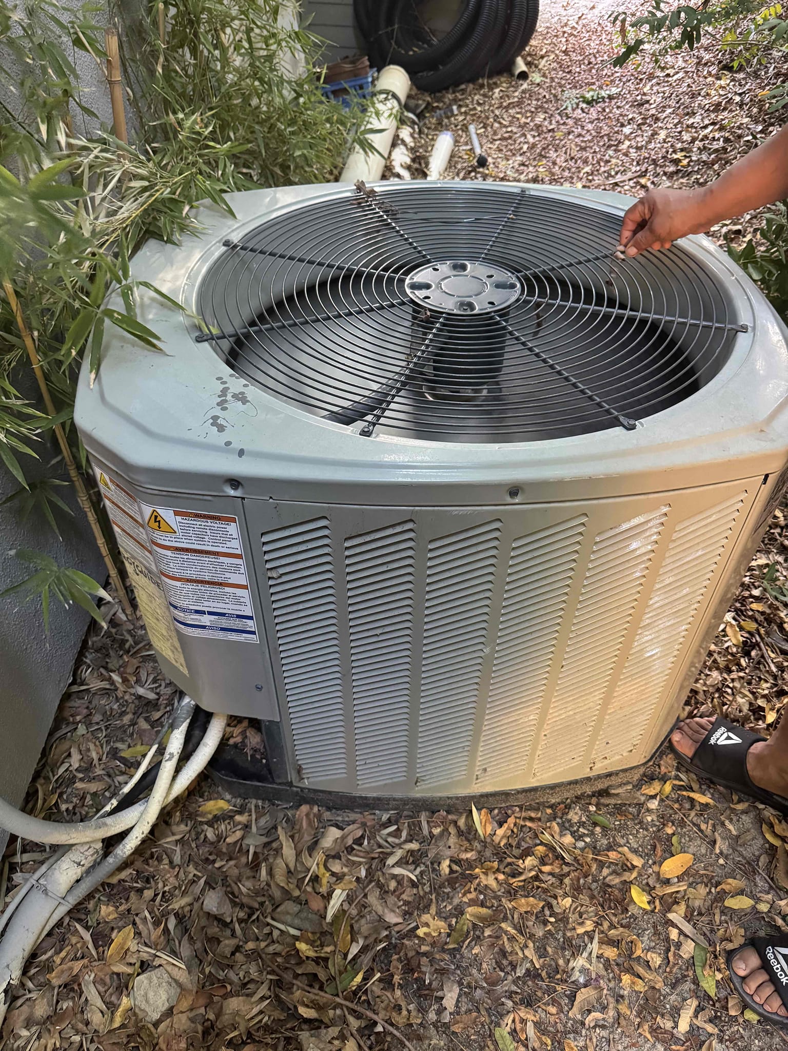 Upon arrival, I assessed the homeowner's concern about the system cycling without producing cool air. The unit in question is a 2014 American Standard 4-ton R410A system. Inspection revealed that the outdoor unit was heavily soiled with dirt, debris, and surrounded by foliage, hindering proper airflow. The 7.5 µF condenser fan capacitor tested at 3.3 µF, indicating failure and potential intermittent fan operation. While operating, the system showed a temperature split that improved from 19.1°F to 24.4°F. I recommend replacing the failed capacitor, thoroughly cleaning the outdoor coil, and removing all foliage and debris around the unit to restore proper airflow and system reliability.