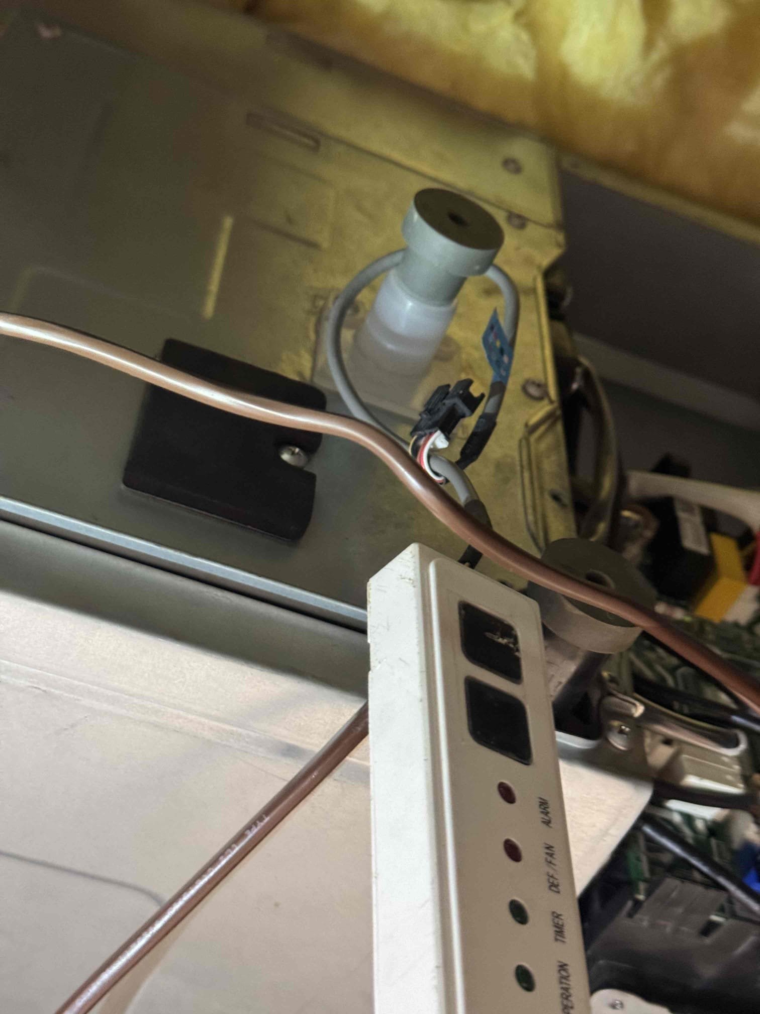 Upon arrival, the ACiQ system was non-operational, with the air-handler blower rattling above 20% operation. The thermostat displayed an EH61 error. After power restoration, the unit briefly started then shut down with a water-level alarm. A test with the CN5 water connection disconnected allowed it to run for five minutes without cooling, displaying EH0E. The T2 sensor measured 8.35 �, and the blower was unbalanced. Refrigerant pressures were 222.5/222.9 psig. Recommend replacing the indoor control board, CN47 T2 sensor harness, and CN5 water-level harness, and addressing the blower issue.