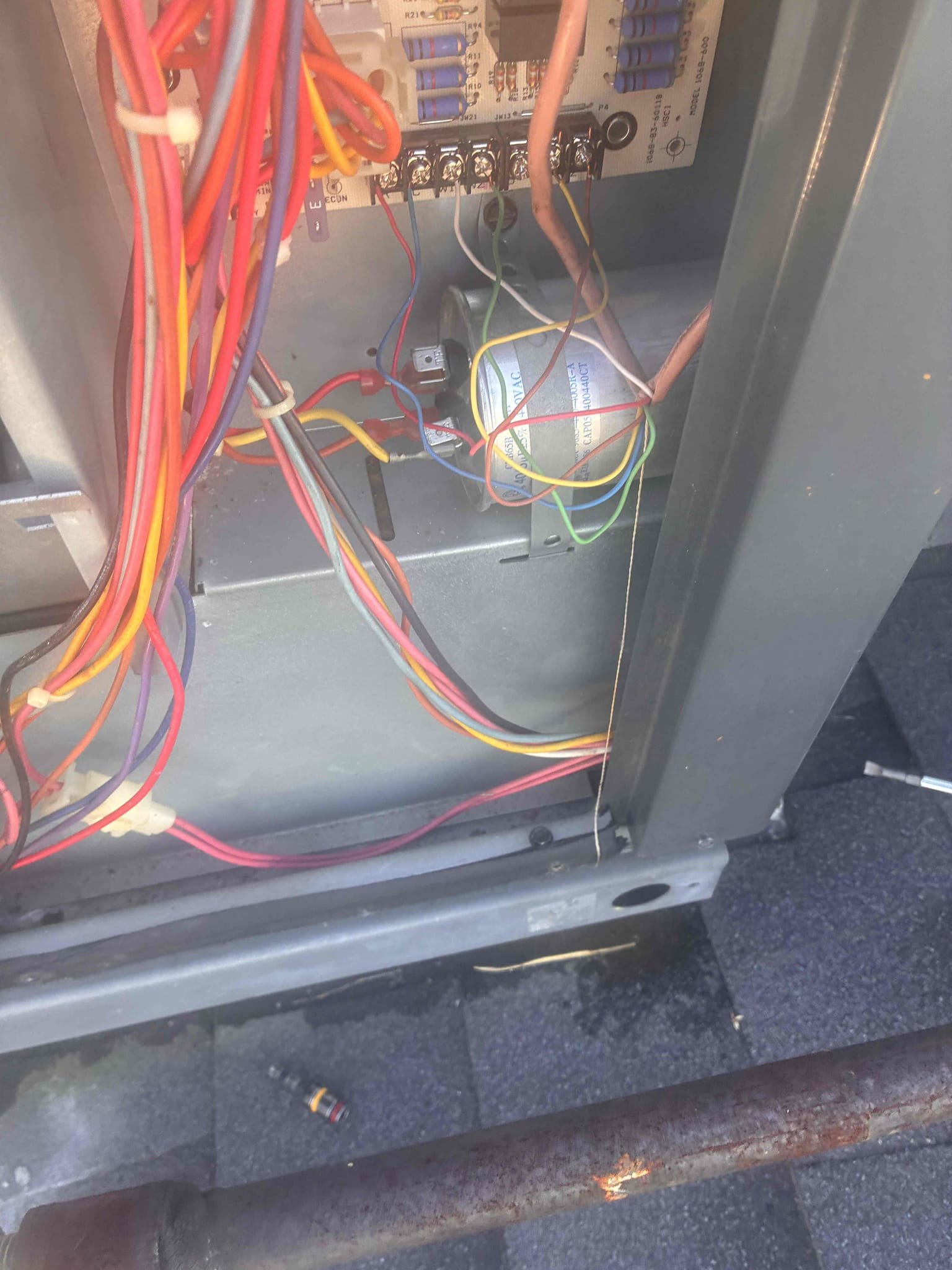 Upon arrival, I confirmed the Goodman package unit was not cooling. The system was not starting, and the outdoor unit was non-operational. After checking power and finding it present, I manually engaged the contactor. The compressor and outdoor fan motor didn't start initially. Inspection revealed damaged wires with heat damage from contact with copper refrigerant piping. The compressor had overheated, triggering thermal overload. After cooling, the compressor started, but the fan motor remained non-operational. The capacitor was below acceptable levels, and the fan motor had failed. Repairs include replacing the fan motor, capacitor, damaged wiring, and securing wiring away from refrigerant lines.
