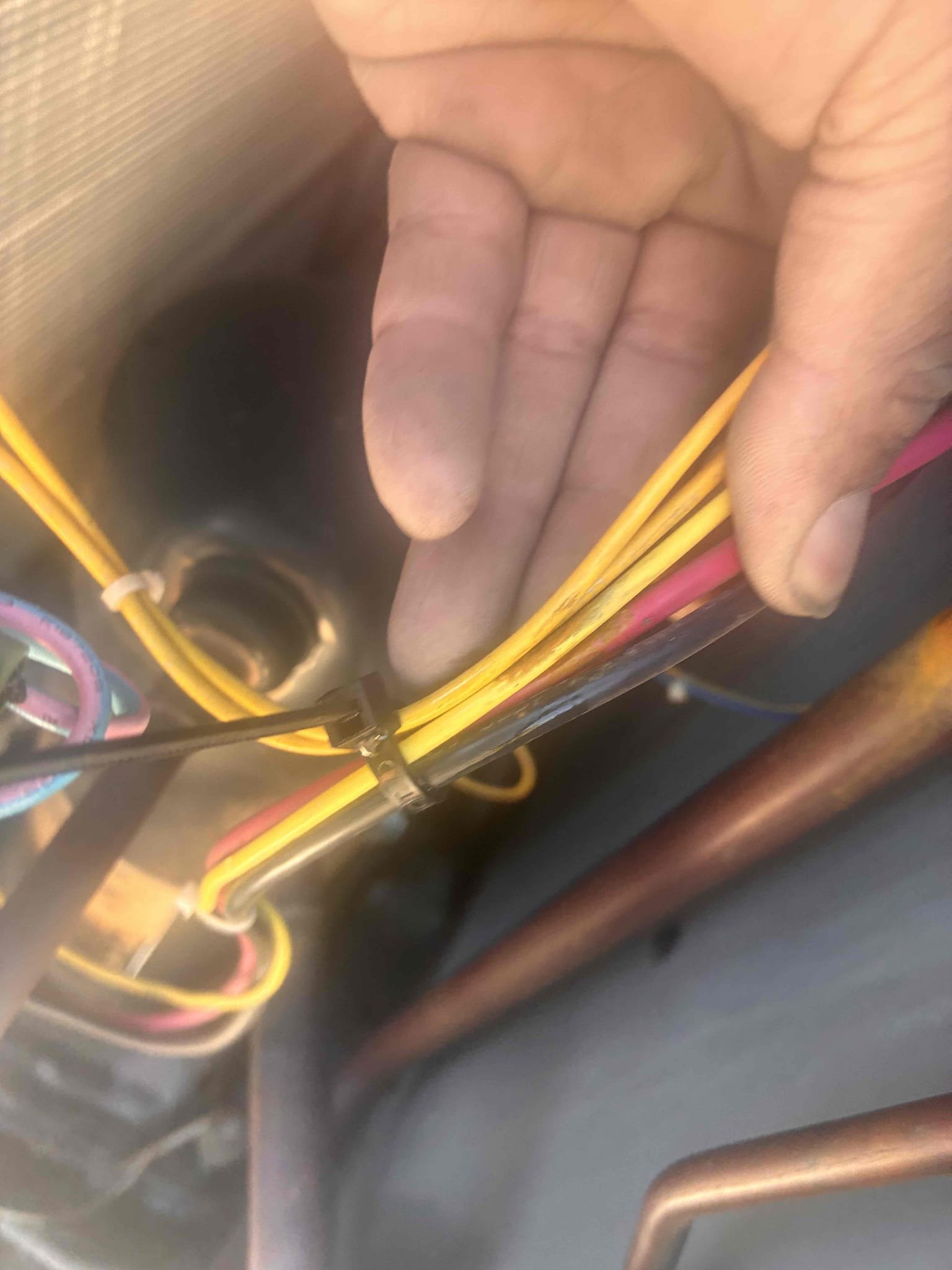 Upon arrival, I confirmed the Goodman package unit was not cooling. The system was not starting, and the outdoor unit was non-operational. After checking power and finding it present, I manually engaged the contactor. The compressor and outdoor fan motor didn't start initially. Inspection revealed damaged wires with heat damage from contact with copper refrigerant piping. The compressor had overheated, triggering thermal overload. After cooling, the compressor started, but the fan motor remained non-operational. The capacitor was below acceptable levels, and the fan motor had failed. Repairs include replacing the fan motor, capacitor, damaged wiring, and securing wiring away from refrigerant lines.