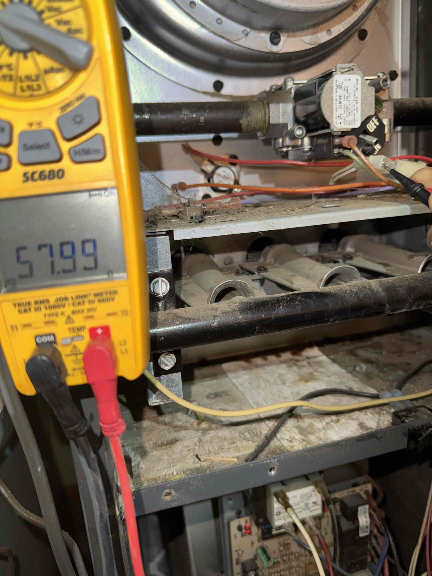 I responded to a furnace issue where it attempted to start but shut down. The furnace, a Goodman GMS80703AXA, showed the inducer operating and the hot surface igniter glowing. The igniter measured 57.99 Ω, and the gas valve’s local switch was ON. Despite 27 VAC at the gas valve and steady inlet gas pressure, no gas flow was detected at the valve outlet. Consequently, the burners did not ignite, preventing the heating cycle from completing. The gas valve is likely faulty and needs repair.