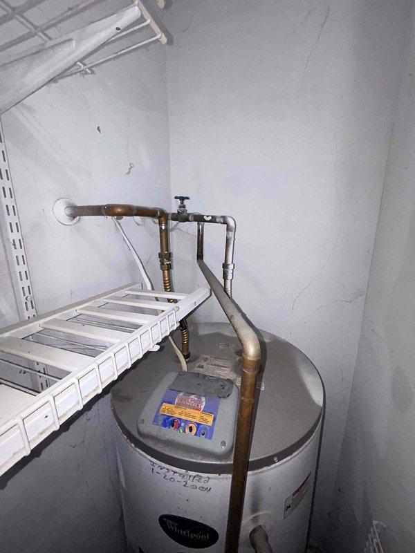 Performed standard plumbing preventative maintenance inspection of residential unit. Inspected laundry area washing machine connections finding hot and cold water supply lines and hoses in good working condition with no leaks present. Examined Whirlpool water heater system including inlet/outlet pipes, shut-off valve, and surrounding copper plumbing infrastructure; all components found to be functioning properly with no visible leaks or immediate concerns.