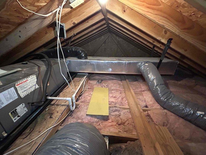 Conducted system replacement assessment on an 8-year-old electric HVAC system reported to be producing excessive noise/squealing audible to neighboring residents. Inspection of attic-installed air handler revealed deteriorating components contributing to the operational noise. Documented current installation configuration including flexible ductwork routing, electrical connections, and mounting structures to prepare comprehensive replacement quote for customer.
