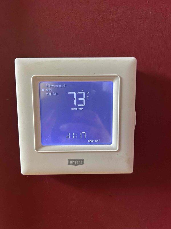 Performed annual maintenance service on a 10-year-old geothermal system located in the basement. Checked and verified thermostat operation (Bryant digital) which was set to "follow schedule" and displaying proper heat functionality. Conducted moisture readings with measurement device showing acceptable levels (31.0) during inspection of the system components.