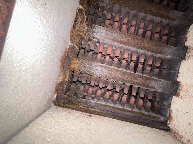 Responded to service call for no heat complaint. Inspected vintage cast iron radiator system and found stripped bleed valve requiring replacement on one unit. Examined boilers which showed significant oxidation and debris accumulation on heat exchanger coils. Replaced defective bleed valve and performed thorough cleaning of heat exchanger components to restore proper system functionality.