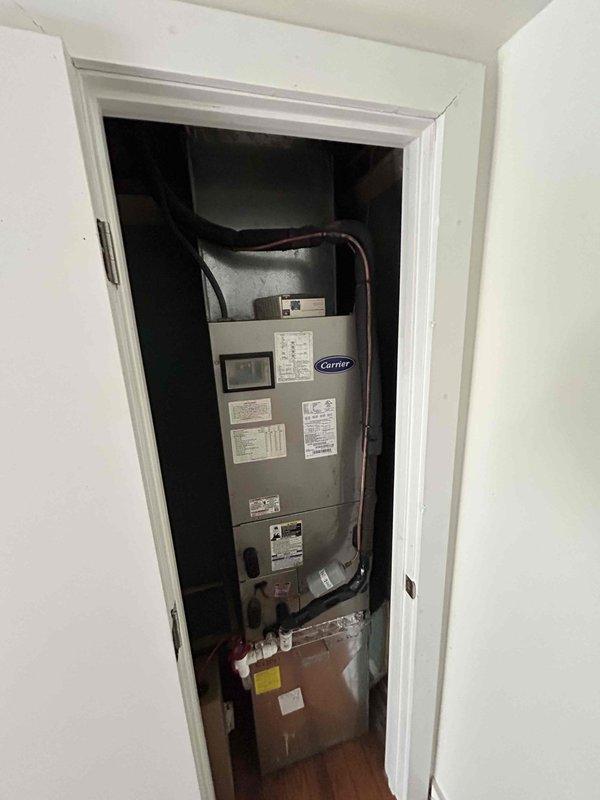 Conducted replacement estimate for Carrier heat pump system with upstairs air handler. Existing system inspection revealed functional Honeywell digital thermostat (currently reading 66°F) and utility closet-installed Carrier furnace unit with standard copper linesets and PVC connections. Customer seeking options but has not determined replacement timeline and does not require financing.