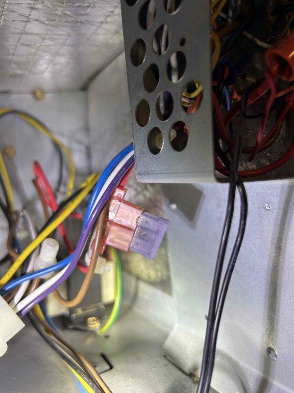 Diagnosed a no-heat issue on a 15-year-old electric heat pump system. Inspection revealed faulty wiring connections at the thermostat - removed and examined the Honeywell thermostat mounting plate to verify proper terminal connections. Also inspected the control board housing in the indoor unit located in basement, finding several loose wire connections which were secured. System tested operational after repairs with proper heating function restored.