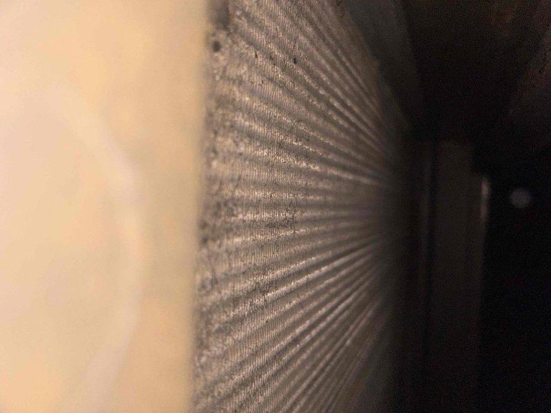 Performed routine maintenance on commercial HVAC system located in basement. Removed and cleaned washable filters which showed significant dust accumulation. Inspected cooling coils which exhibited extensive corrosion and rust buildup around tube mounting points, indicating potential moisture issues that may require future attention.