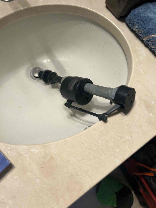 Identified and replaced faulty toilet fill valve that was continuously allowing water to leak into the flush valve despite the float cup reaching its stopping position. Removed old assembly showing mineral buildup, installed new fill valve mechanism to restore proper water shutoff function and eliminate continuous running.