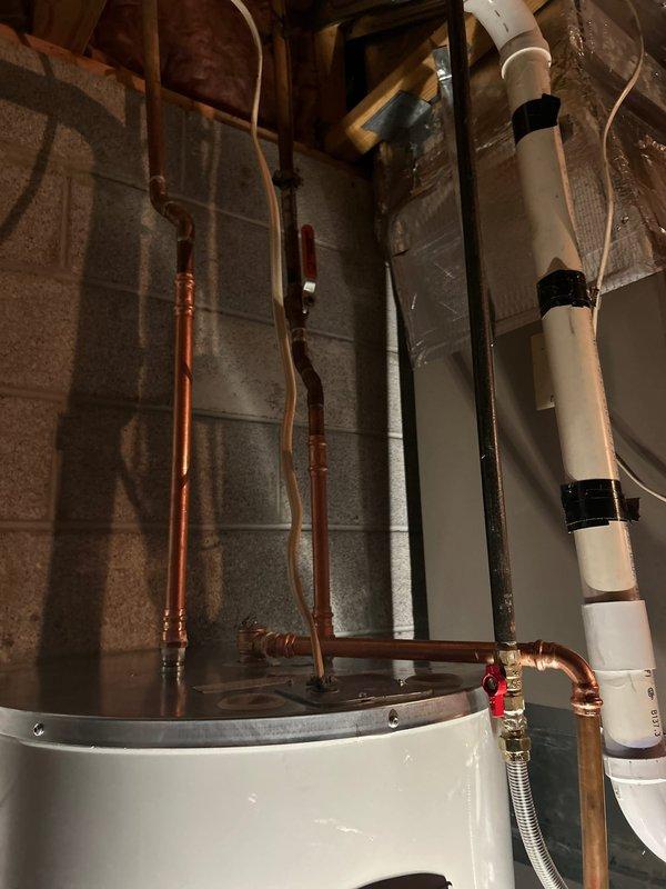 Successfully replaced a 50-gallon Bradford White electric water heater in utility area. Installed new copper supply lines with appropriate valves and fittings. Connected PVC discharge piping according to code requirements.
