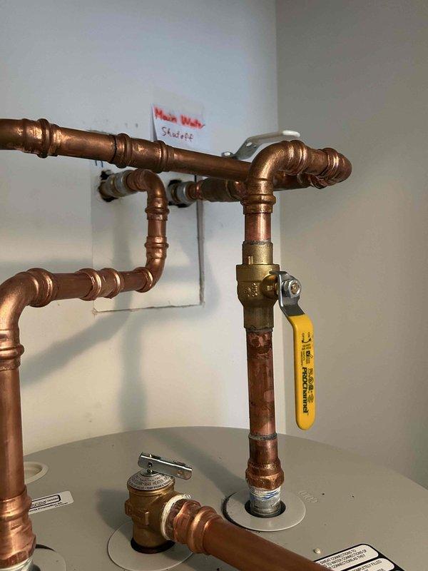 Replaced cracked plastic drain pan with new metal drain pan beneath recently installed water heater per homeowner's request. Verified proper installation with no leaks at connections. All water heater systems functioning correctly after service.