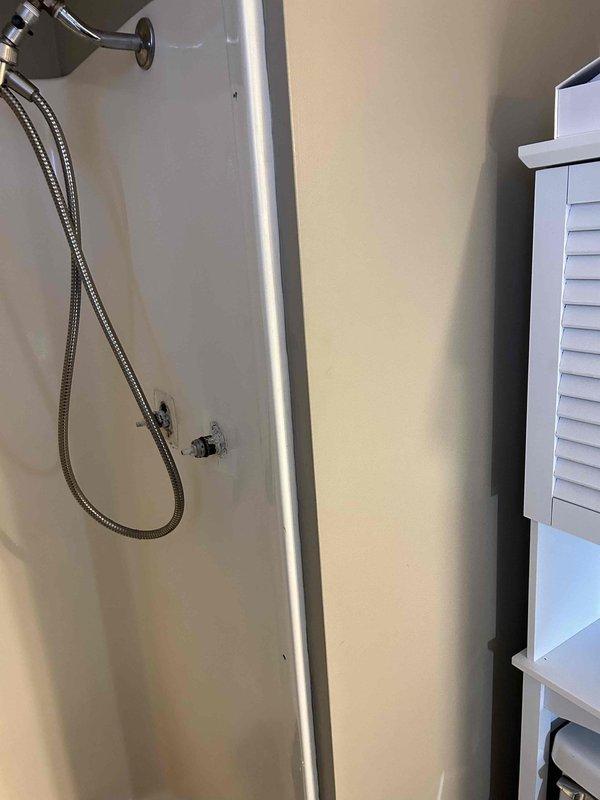 Inspected and repaired shower/tub pressure valve in master bathroom where client reported non-functioning knob with continuous dripping. Discovered damaged valve assembly requiring replacement, with water intrusion evident around fixture mounting point. Installed new pressure-balancing valve and verified proper operation, resolving both the functionality issue and eliminating the persistent leak.