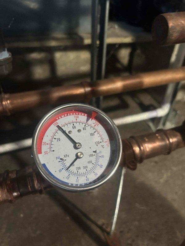 Completed annual Care Plan tune-up on LP boiler located in basement. Inspected all plumbing connections including brass shutoff valve and fittings. Checked temperature and pressure readings on system gauge, confirming proper operation at approximately 20°C with normal pressure levels.