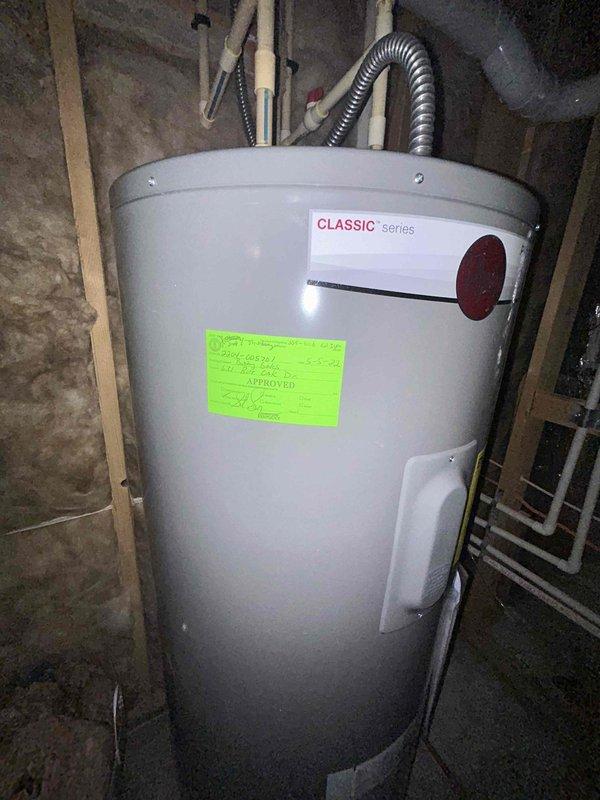 Performed inspection of previously installed water heater kit per PSA request. Examined the Classic series water heater installation in utility area, noting proper connections of PVC pipes and flexible metal conduit. The unit appears to be functioning correctly with an approved certification label present. No defects were identified in the previously installed components.