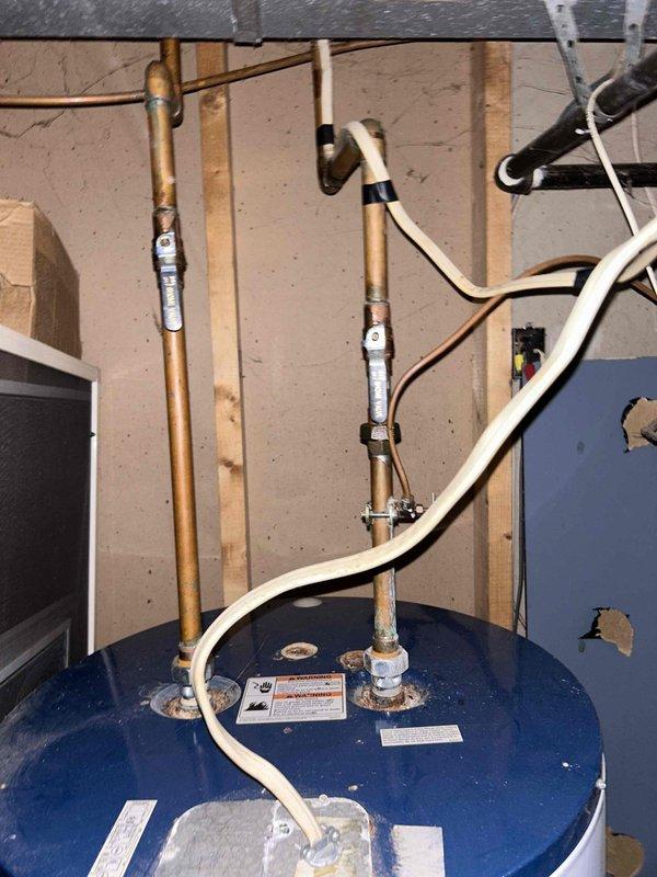 Conducted routine plumbing inspection as part of a PSA service appointment. Examined toilet/sink plumbing connections, noting minor corrosion on water supply line that may require future attention. Inspected water heater system with focus on copper pipe connections and drainage components, confirming proper installation and functional operation of all elements.