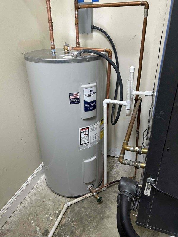 Successfully installed a 50-gallon Bradford White electric water heater, replacing the previous unit. Properly drained the old heater before disposal. Connected the new unit to the existing geothermal system via a tee fitting at the bottom of the tank. Completed all necessary copper pipe connections, verified proper functionality, and confirmed no leaks present upon completion. Installation includes 6-year tank/parts warranty and 1-year labor warranty.