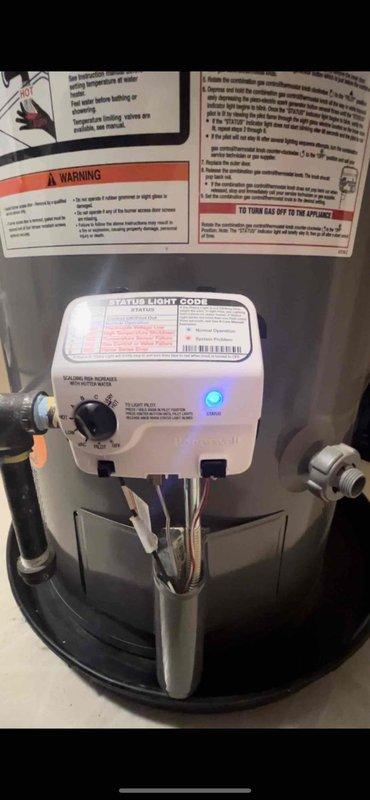 Diagnosed water heater (Rheem model, 4-5 years old) that was not producing hot water. Verified power supply was functioning with blue indicator light active on control panel. Inspected combustion chamber through viewing window and confirmed proper blue flame operation, indicating burner assembly was working correctly. Adjusted temperature setting from lower position to appropriate temperature range to restore normal hot water operation.