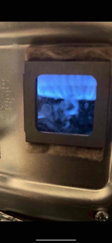 Diagnosed water heater (Rheem model, 4-5 years old) that was not producing hot water. Verified power supply was functioning with blue indicator light active on control panel. Inspected combustion chamber through viewing window and confirmed proper blue flame operation, indicating burner assembly was working correctly. Adjusted temperature setting from lower position to appropriate temperature range to restore normal hot water operation.