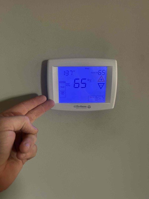 Completed geothermal system tune-up service on two units located in basement and attic as part of customer's Care Plan agreement. Inspected Aire brand HVAC system in utility area with proper ductwork and connections. Verified thermostat operation (heat mode functioning correctly with temperature reading at 65°F) and confirmed system response to controls.