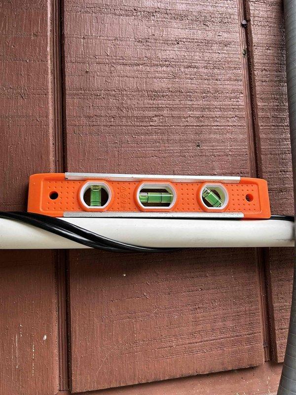 Completed warranty installation of ODU drain kit to address water drainage issues. Installed drain plug connector at active drainage point, extended with PVC pipe secured along exterior wall, and connected to existing condensate line. Added heat tape along entire drain line with weatherproof 120V receptacle installed off disconnect to prevent freezing.