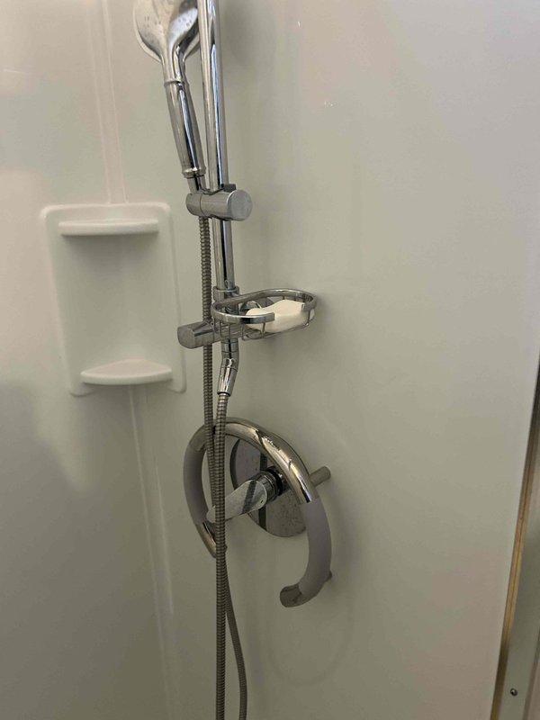 Conducted routine plumbing inspection as part of preventive service agreement. Examined water heater system, checking all connections, exhaust venting, and supply pipes for proper installation and potential leaks. Also inspected bathroom shower fixture, including handheld showerhead, sliding rail system, control valve, and flexible hose connection - all components found to be in good working condition with no visible issues.