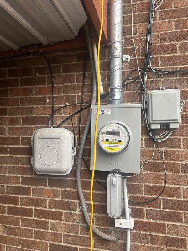 Inspected customer's electrical system to address reported issue with lights flickering throughout the house when turned off. Visual examination of the exterior service entrance, meter installation, and panel connection revealed no obvious defects. Service panel appears to be properly installed with standard Milbank meter and appropriate conduit connections.
