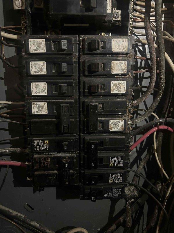 Completed electrical assessment for customer's multiple code compliance projects required by KU. Performed inspection of main electrical distribution panel which showed aging wiring, cluttered wire bundles, and mixed breaker types. Panel exhibited signs of wear with various wire gauges and inconsistent organization that would need to be addressed to meet current electrical standards.