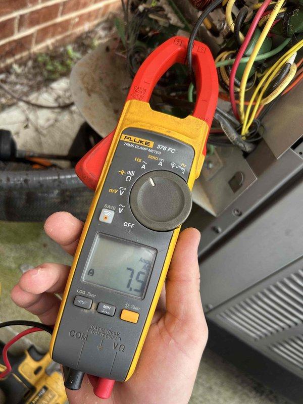 Performed routine Care Plan Tune Up on heat pump/air handler system located in garage. Visual inspection revealed significant buildup on evaporator coil with yellowish-green residue indicating possible mold or corrosion. Conducted electrical diagnostics using Fluke 376 FC clamp meter, measuring 7.9 amps at compressor. System operation verified after service.