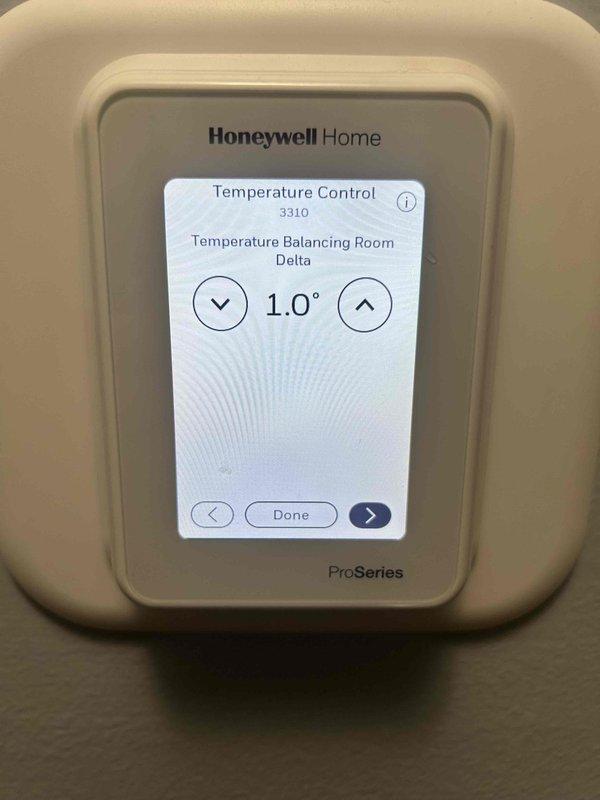 Responded to non-urgent service call regarding uneven heating with reported 10-degree temperature difference between areas of home. Inspected Honeywell Home ProSeries thermostat (model 3310) and adjusted Temperature Balancing Room Delta setting to improve temperature distribution. Additionally, enabled Adaptive Intelligent Recovery feature in thermostat settings to optimize system performance and create more consistent heating throughout the residence.