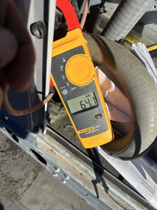 Responded to no heat call for electric HVAC system approximately 3 years old located on rooftop. Conducted electrical diagnostic testing using Fluke 902 FC and Fluke 302+ clamp meters to measure amperage readings on system components, revealing readings of 64.3 and 25.5 respectively. System restored to proper operation after addressing electrical issues causing the fan failure.