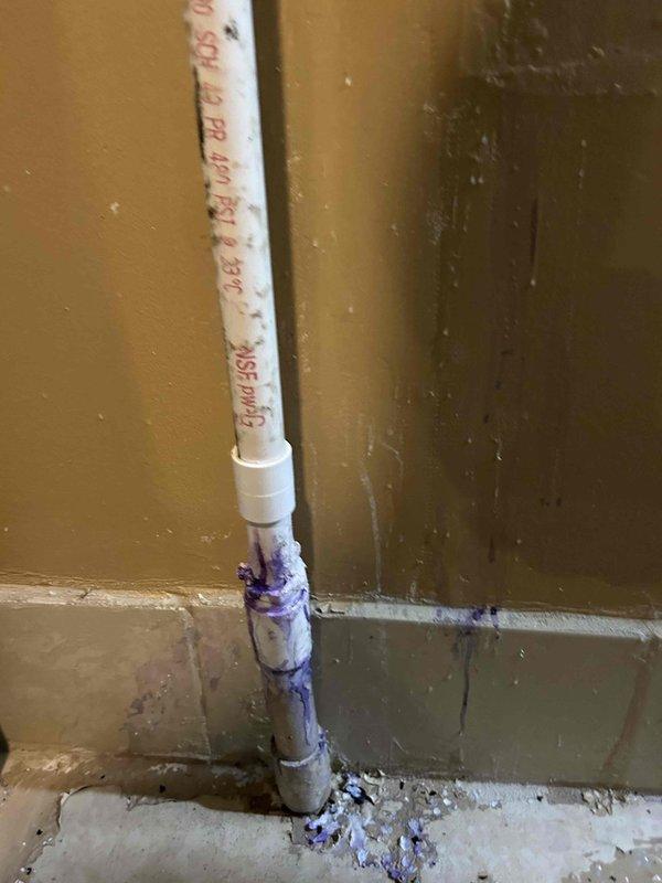 Repaired water leak at water heater by replacing corroded copper supply line connection and green valve assembly showing significant oxidation. Installed new PVC pipe with proper primer and cement at joint connection to resolve steady leak. System tested after repair with water restored to confirm proper operation with no further leakage.