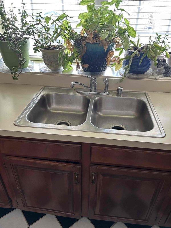 Conducted assessment of kitchen sink area for garbage disposal removal and replacement of sink and faucet. Observed existing disposal unit with signs of corrosion at water supply valve connections and evidence of previous water leakage on cabinet floor. Customer has supplied new fixtures for installation. Service quote provided and customer approval pending for scheduled return visit to complete the replacement work.