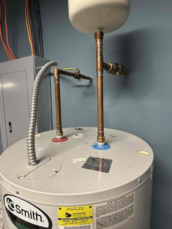Inspected 80-gallon A.O. Smith water heater (2014 model) showing signs of leakage from the base. Unit services front faucets and is located in a storage area. Documented condition with photos including the water heater installation with copper piping and expansion tank, plus the associated electrical panel. No error codes present on the unit.