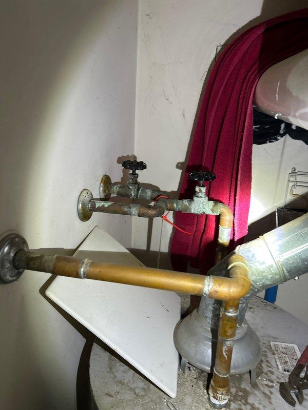 Responded to steady water leak in upstairs bathroom with water already shut off at main. Inspection revealed water damage and deterioration in wooden support beam under the bathroom, with visible moisture damage to joists and OSB sheathing. Identified corroded pipe connections at the shutoff valves as the source of the leak, requiring replacement of affected plumbing components to restore proper function.