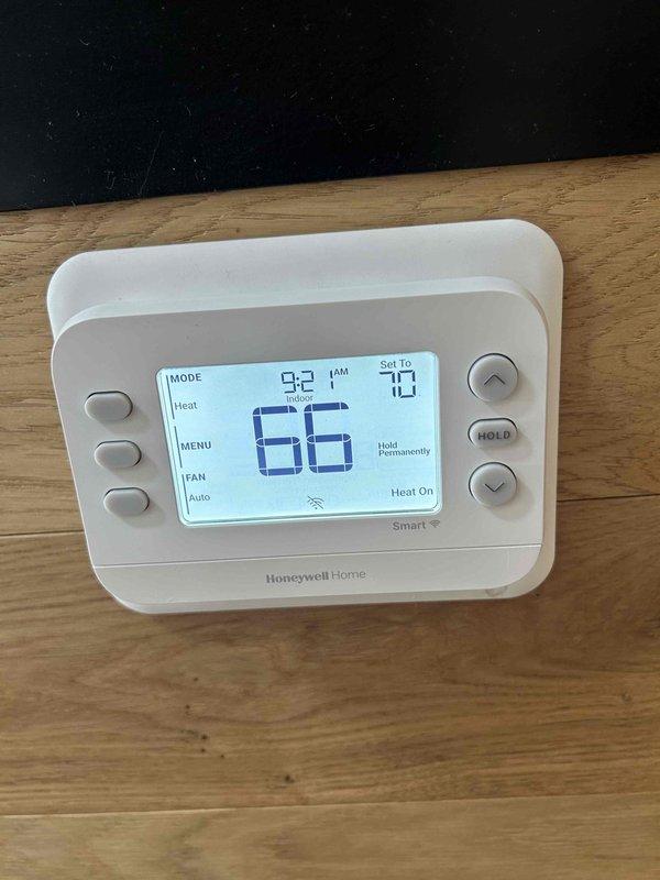 Responded to callback for inoperative lobby thermostat and comfort issues. Diagnosed and replaced dirty air filters causing airflow restriction. Verified proper operation of replacement Honeywell thermostat displaying 66°F with 70°F setpoint in heat mode. System now functioning correctly and maintaining desired temperature.