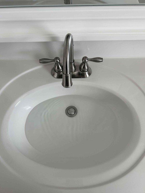 Addressed water leak issues in multiple areas: repaired leaking sink flanges in kitchen and master bath, replaced faulty garbage disposal, fixed toilet refill kit, and corrected plumbing vent in attic by removing test balloon and reinstalling cap. Performed thorough inspection of sink P-trap and drain assembly showing signs of water damage. All affected areas were cleaned and restored to proper working condition.